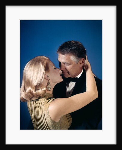 Romantic couple embracing about to kiss husband wife evening dress studio 1970s 1960s by Anonymous