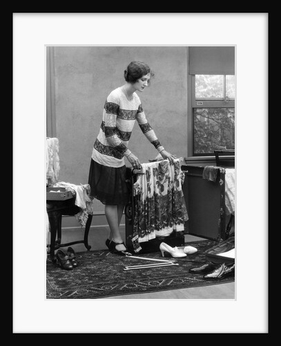 1920s woman packing clothes for travel by Anonymous