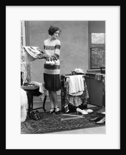 1920s woman packing clothes for travel by Anonymous