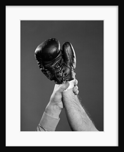 1950s gloved hand of winner of boxing match being held up by referee by Anonymous