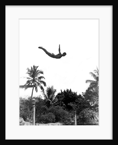 1940s man poised midair arms out jumping from diving board into pool by Anonymous