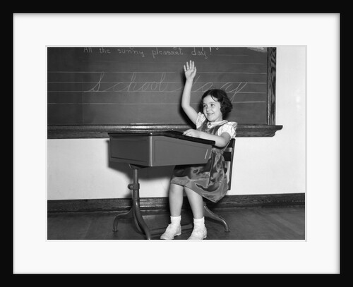 1930s 1940s smiling girl sitting at desk raising her hand by Anonymous
