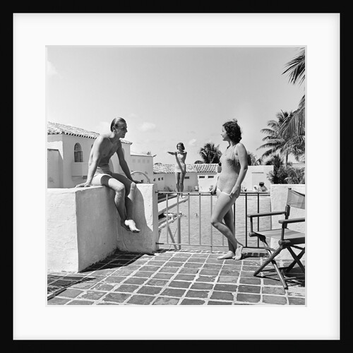 1930s man woman wearing bathing suits on terrace overlooking swimming pool woman on diving board by Anonymous