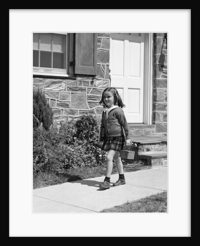 1940s little girl walking to school outside of home doorway carrying lunch box by Anonymous