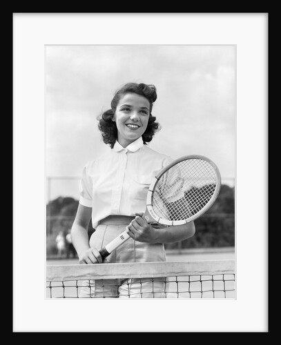 1950s 1940s woman posing with tennis racket on tennis court near net by Anonymous