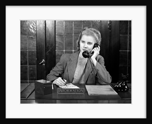 1940s young woman sitting at information desk secretary talking on telephone writing by Anonymous