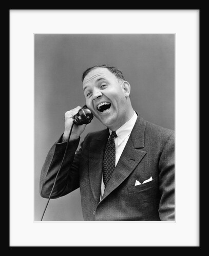 1930s man in suit laughing talking on telephone by Anonymous