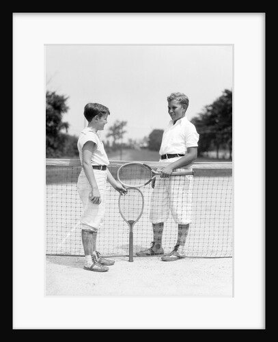 1920s 1930s two boys tennis match holding rackets measuring net height by Anonymous