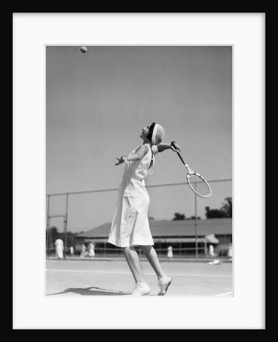 1930s woman playing tennis about to hit ball with racket by Anonymous