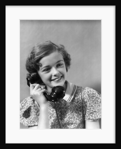 1930s teen girl smiling brunette print dress talking on telephone by Anonymous