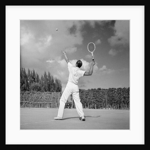 1930s back view of man playing tennis about to hit the ball summer outdoor by Anonymous
