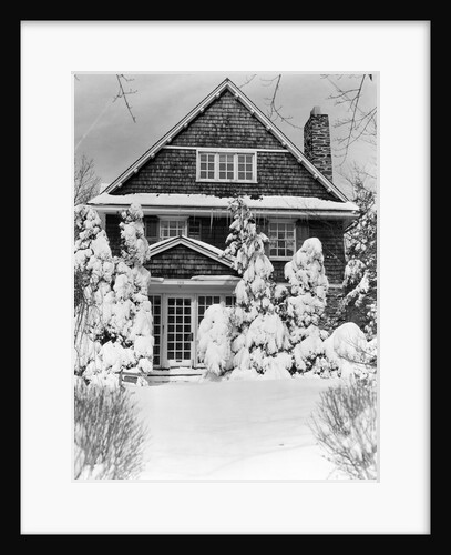 1940s three story shingle style house with pine trees and shrubs covered with snow by Anonymous
