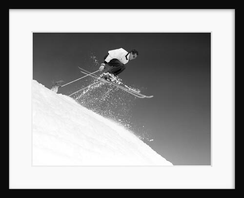 1950s man skier skiing down slope jumping into air by Anonymous