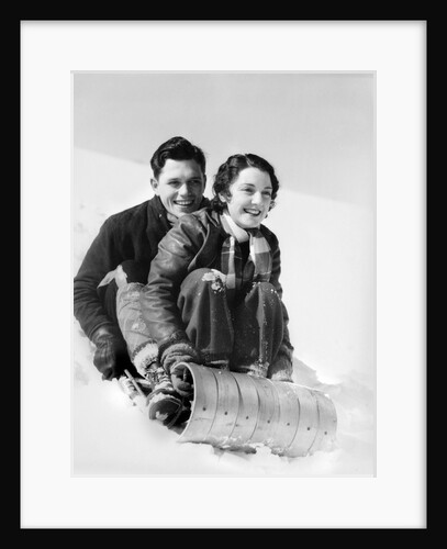 1920s 1930s smiling couple man and woman on toboggan in winter by Anonymous