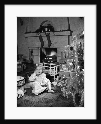 1950s smiling little girl christmas tree talking on toy telephone by Anonymous