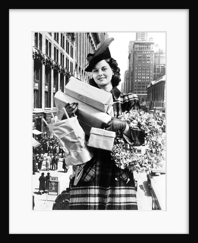 1930s 1940s woman looking at camera arms full with christmas shopping packages & wreath composite with street scene by Anonymous