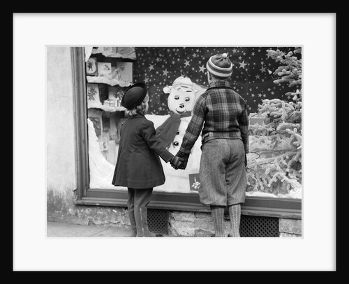 1930s back view boy and girl holding hands looking at decorated christmas window by Anonymous