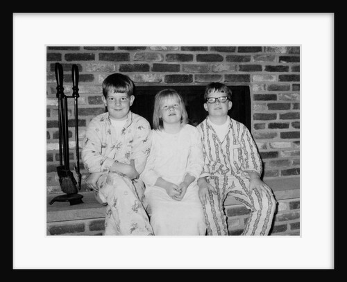Siblings pose on the hearth in pajamas, ca. 1970. by Anonymous