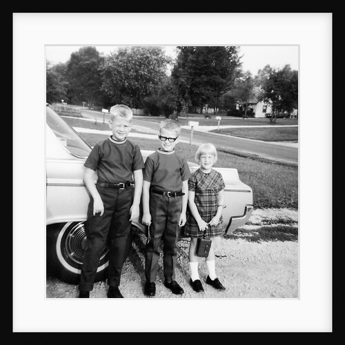 A lineup of kids by the family car. 1965. by Anonymous