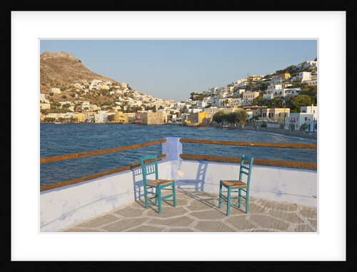 Chairs on terrace, town in background, Agia Marina, Leros, Greece by Anonymous