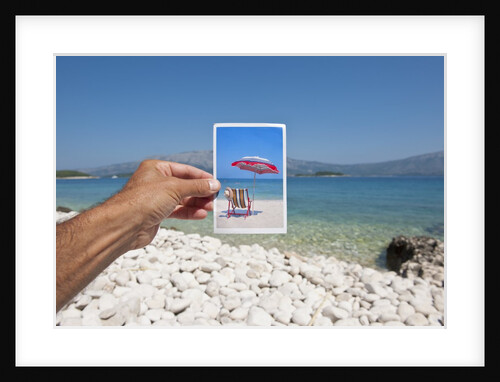 Hand holding photograph depicting deck chair and sunshade, Lumbarda, Korcula island, Croatia by Anonymous