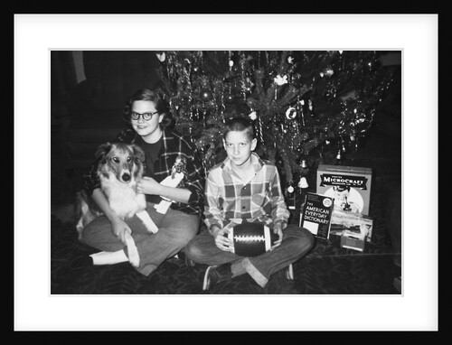 Brother and sister pose by the Christmas tree, ca. 1960 by Anonymous
