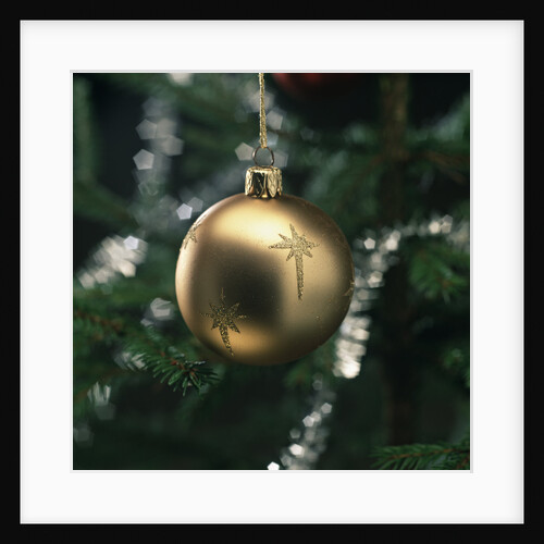 Close-up of a golden hanging Christmas bauble on blurred tree by Anonymous