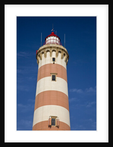 Barra lighthouse located on the ocean coast in the fishing village of Costa Nova by Anonymous