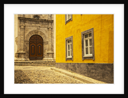 A street in Tavira leading to the entrance of a church by Anonymous
