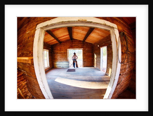 Cowgirl in doorway of old cabin by Anonymous