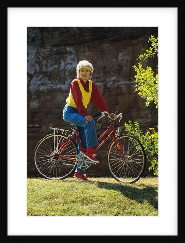 1980s Senior Woman On Bicycle Standing Still Looking At Camera by Anonymous