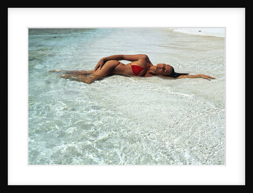 1990s Woman In Red Bikini Lying In Shallow Water On The Beach by Anonymous