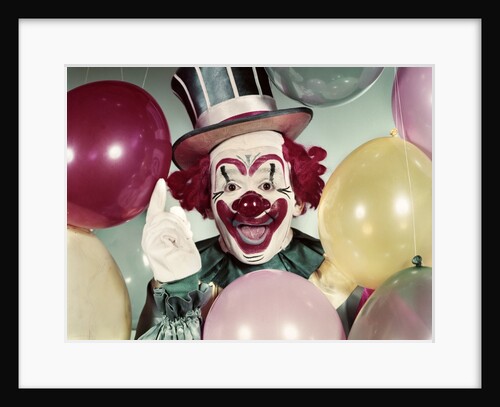 1950s Circus Clown Portrait Smiling Amid Balloons Pointing Up Looking At Camera by Anonymous