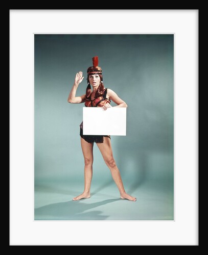 1960s 1970s Character Woman Wearing Native American Feather Headdress Making How Gesture Holding Blank Sign Looking At Camera by Anonymous