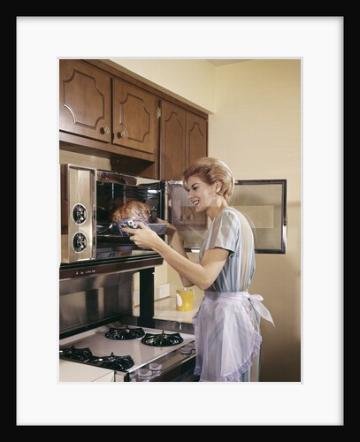 1960s Woman Housewife In Apron Oven Baking Cooking Roast In Kitchen by Anonymous
