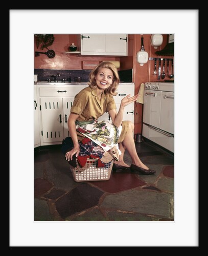 1960s Young Blond Housewife Smiling Sitting On Top Laundry Basket by Anonymous