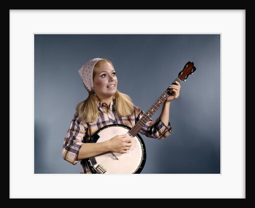 1960s Young Blonde Woman Wearing Plaid Shirt Playing Banjo Singing Folk Music by Anonymous