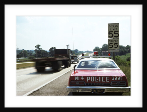 1970s Police Car With Radar Gun Checking For Speeders In 55 Mph Speed Zone by Anonymous