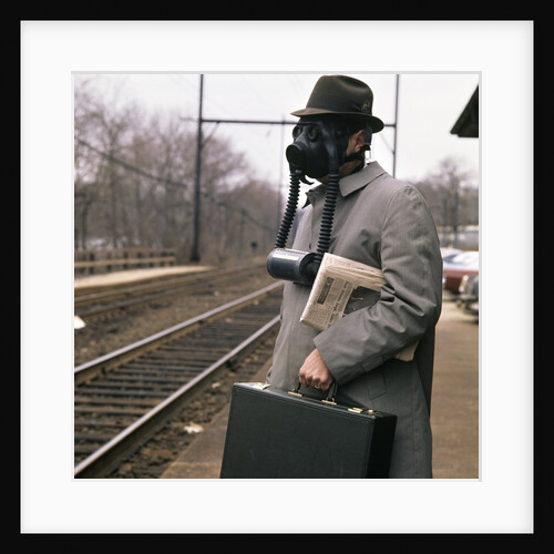 1970s 1960s Man Commuter Waiting For Train Wearing Gas Mask Pollution by Anonymous