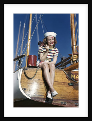 1940s Smiling Woman Wearing Nautical Sailor Outfit And Hat Sitting On Edge Of Boat Holding Paint Brush by Anonymous