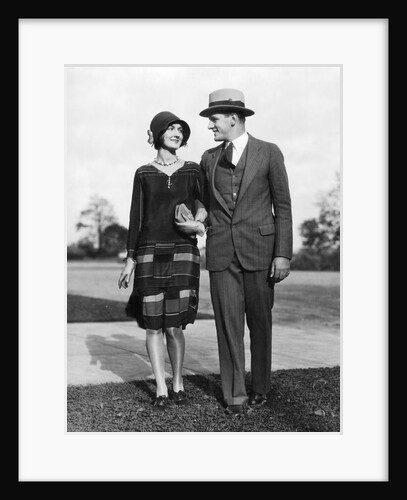 1920s Portrait Smiling Stylish Couple Walking Arm In Arm by Anonymous