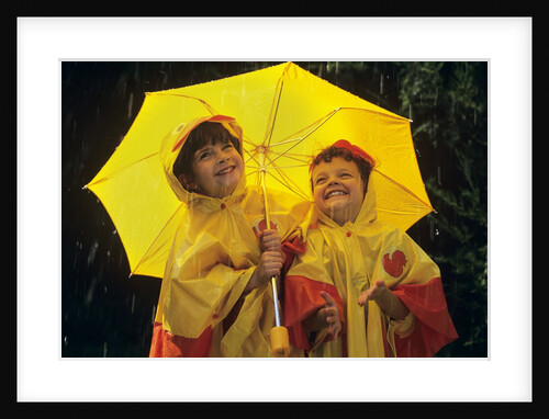 1990s Two Laughing Young Girls Holding A Yellow Umbrella And Wearing Yellow Rain Ponchos by Anonymous