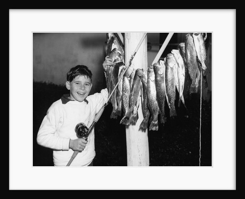 1950s Smiling Boy Proudly Displaying His Fish Catch Looking At Camera by Anonymous