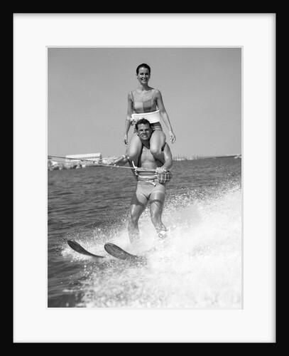1960s Man Water Skiing With Woman In Bathing Suit Riding On Shoulders by Anonymous