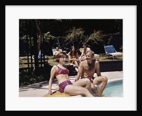 1960s Four People On Patio Couple Man Woman Sitting On Edge Of Swimming Pool by Anonymous