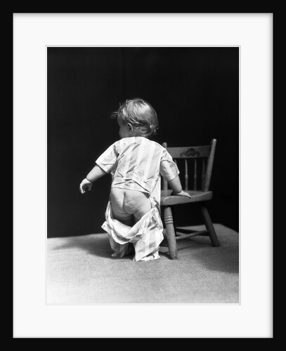 1930s Baby Wearing Drop Seat Pajamas Showing Bare Bottom Leaning On Chair by Anonymous