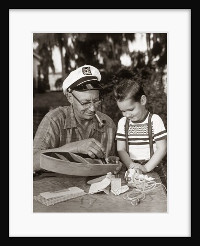 1960s 1950s Young Boy With Smiling Grandfather Building Model Boat by Anonymous