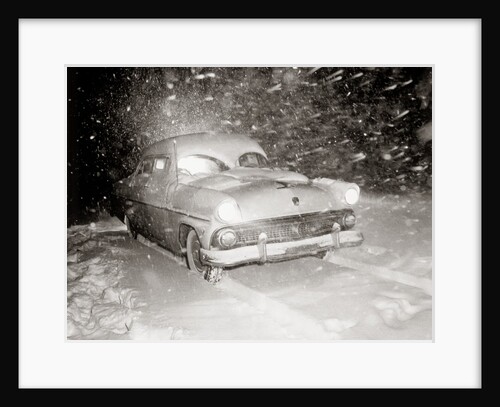 1950s Snow Covered Automobile Driving On Road In Deepening Winter Blizzard Snow by Anonymous