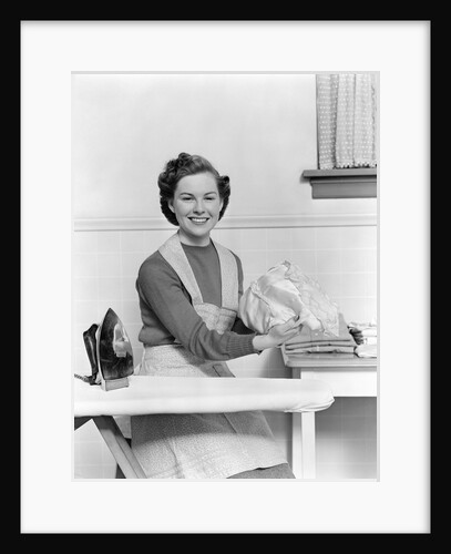 1940s Woman Sitting At Ironing Board Smiling Looking At Camera by Anonymous