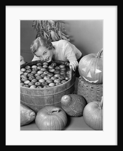 1950s Smiling Woman Leaning Over Wooden Tub Filled With Water About To Begin Bobbing For Apples by Anonymous
